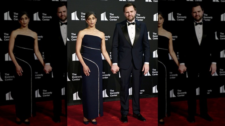 Dressed in a strapless navy blue gown, Usha Vance holds hands with JD Vance on the red carpet