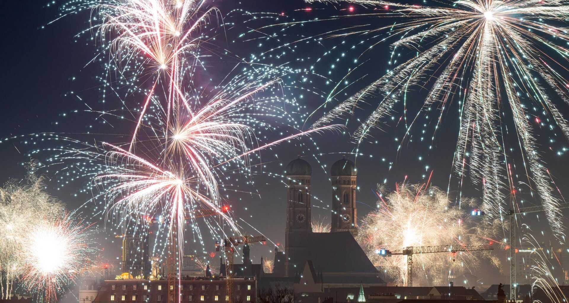 Feuerwerksraketen erleuchten in der Silvesternacht den Himmel über München