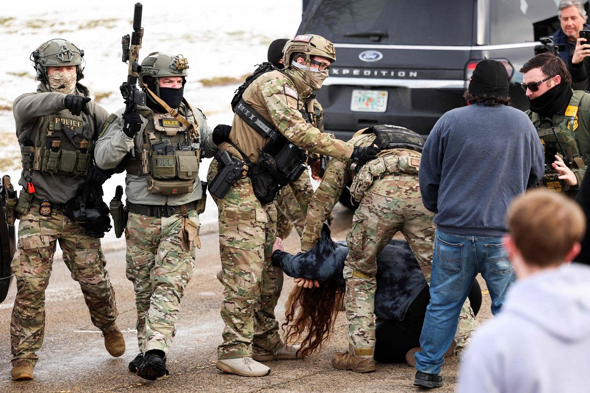 Armed US Federal agents arrest someone protesting against the actions of ICE