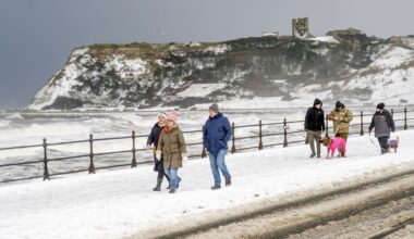 People walk down the snow-covered seafront in Scarborough. Pic: PA