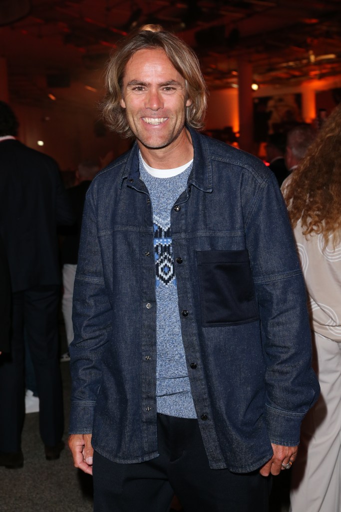 Stuntman Ueli Kestenholz smiles, wearing a denim jacket over a blue patterned sweater.