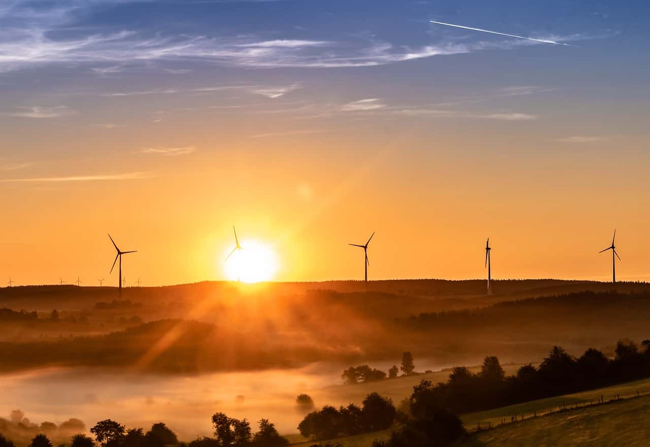 Renewable energy wind turbines sunset landscape.