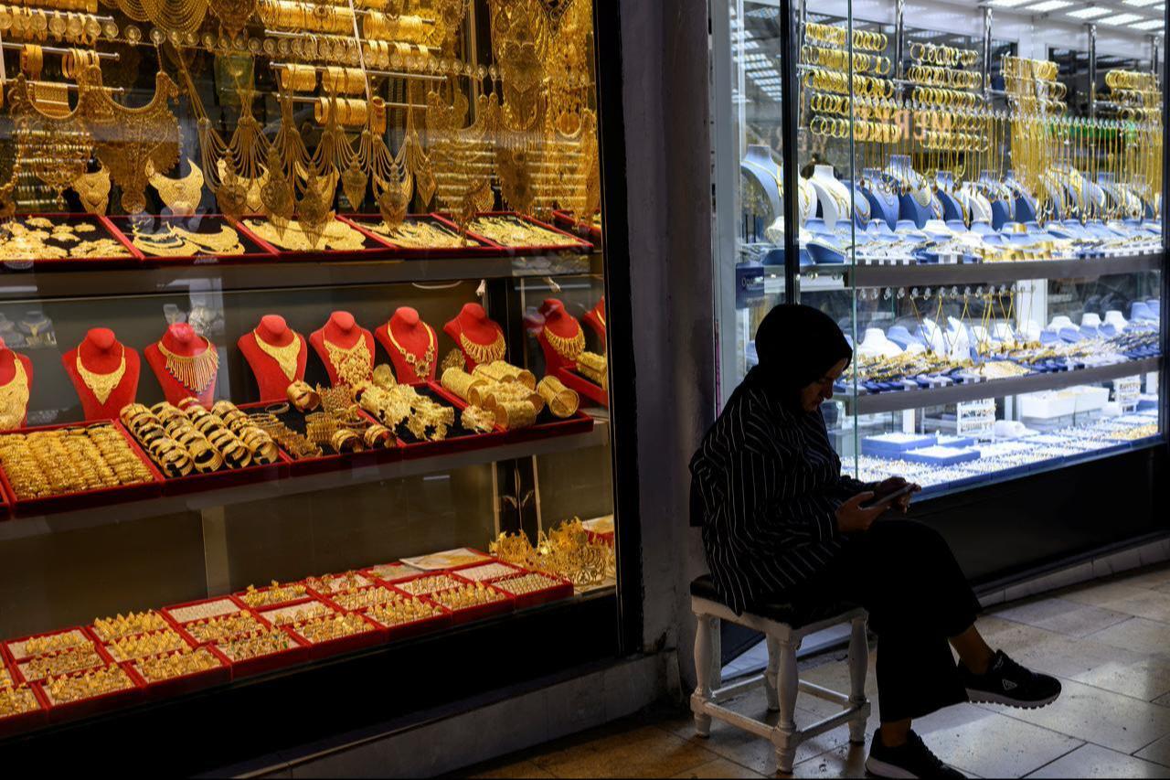 A woman sits in front of a gold shop at the Grand Baazar in Istanbul, Türkiye on October 10, 2025. (AFP Photo)