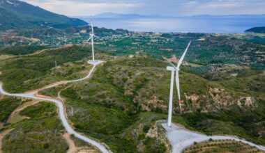 Wind turbines are seen atop green hills overlooking the Aegean Sea in western Türkiye. (Adobe Stock Photo)