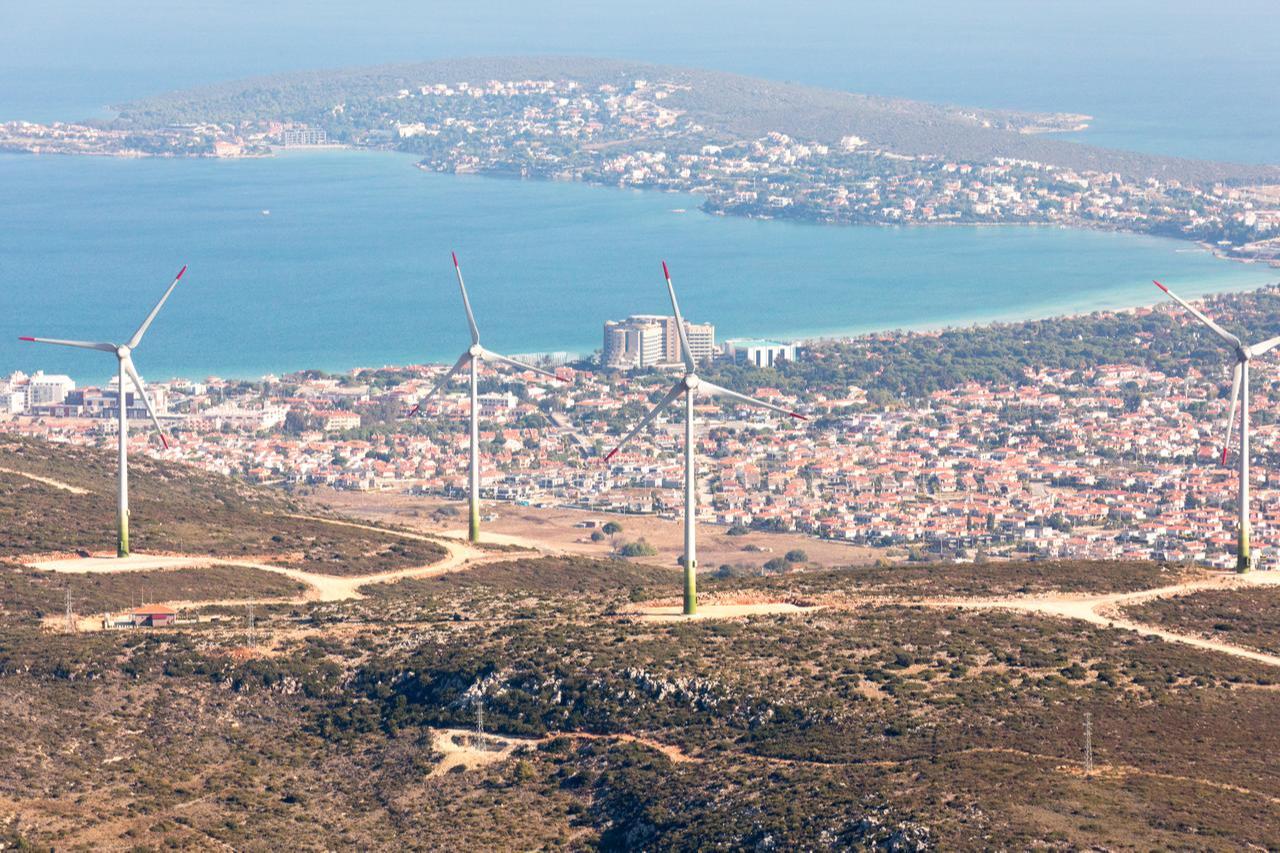 Wind turbines overlook a coastal town in western Türkiye, accessed on June 17, 2025. (Adobe Stock Photo)
