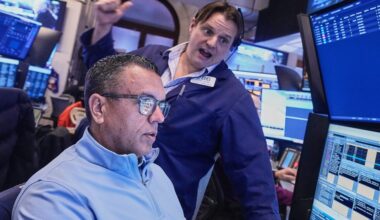 Wall Street flirts with a record as stocks zigzag following mixed profit reports