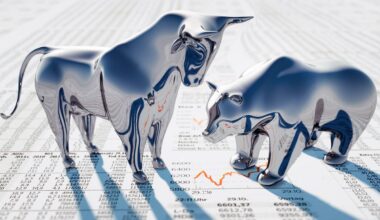 A silver bull towers over a silver bear, both of which stand on newsprint.