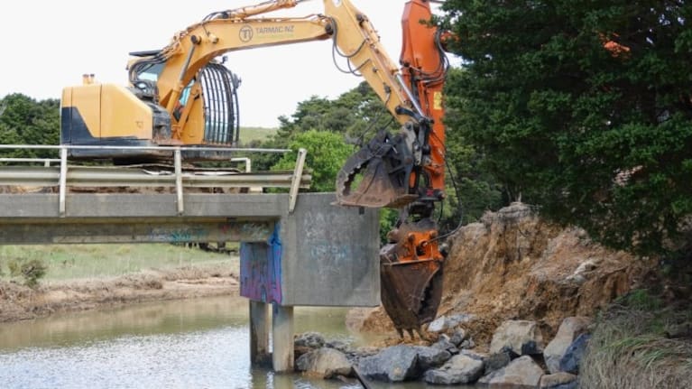 Work to reinstate a washed-out bridge at Ngaiotonga started on Friday, once diggers could reach the area.