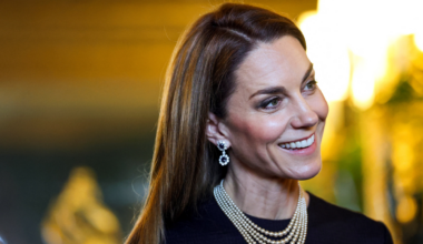 Princess Kate wearing a pearl necklace and sapphire earrings and smiling