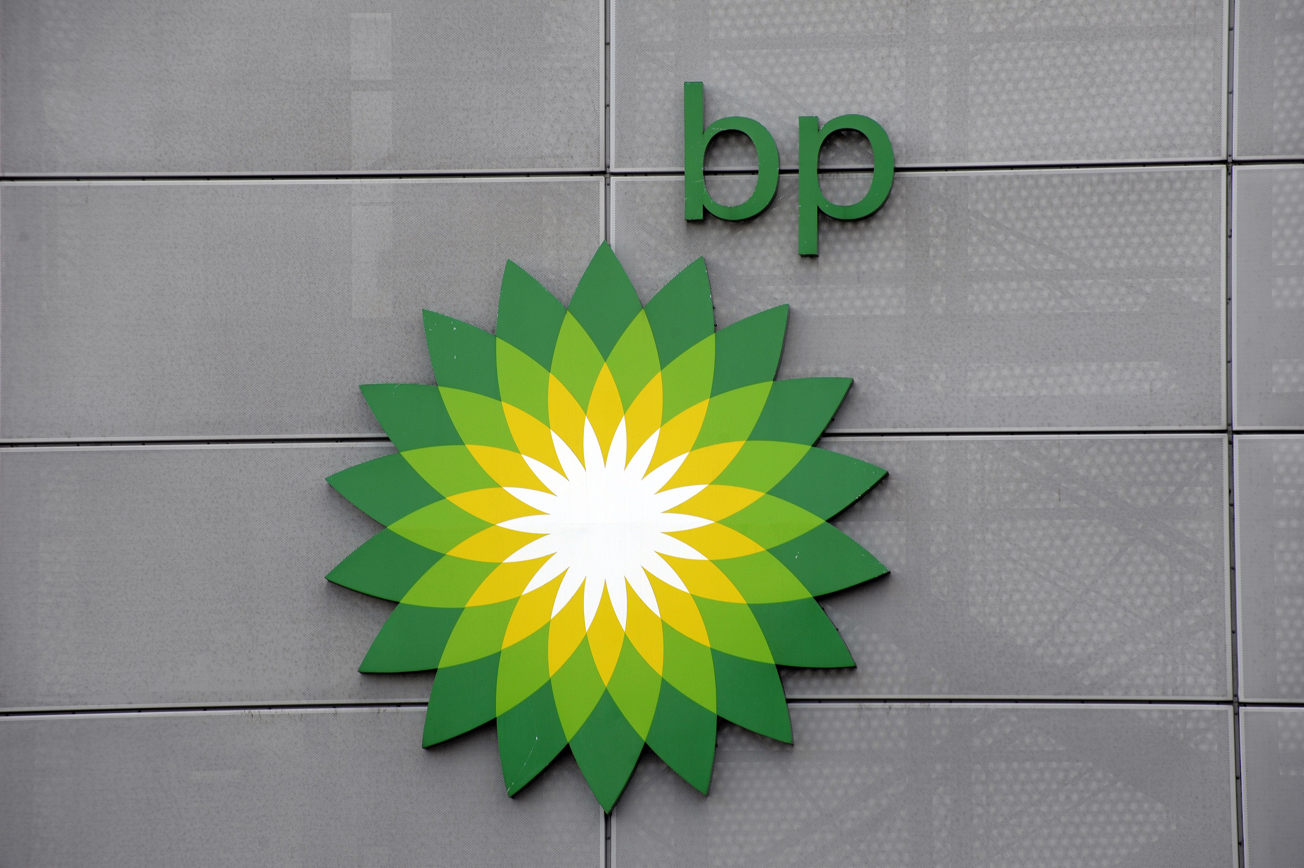 The BP logo, a green and yellow sunburst, and the letters "bp" on a gray wall.