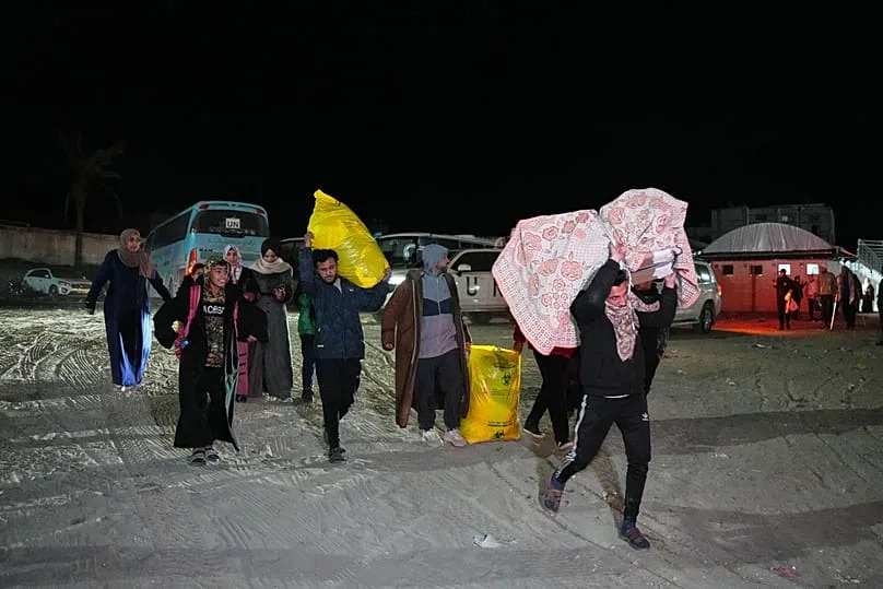 Des Palestiniens transportent les effets personnels de membres de leur famille arrivant à Gaza en provenance d'Égypte après la réouverture tant attendue du poste-frontière de Rafah, à Khan Younis, le 5 février 2026.