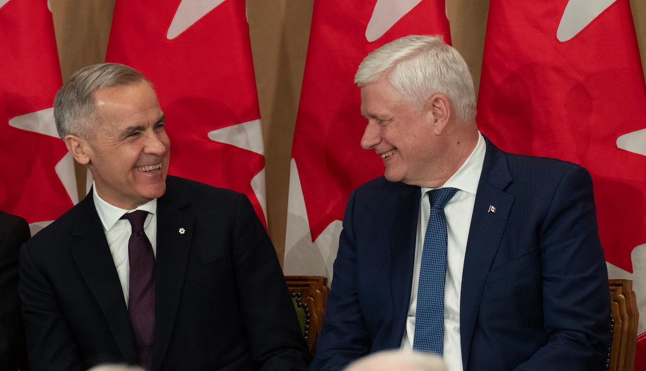 Former prime minister Stephen Harper, right, and Prime Minister Mark Carney share a laugh during a ceremony for Harper's official portrait unveiling in Ottawa, on Tuesday, Feb 3, 2026.