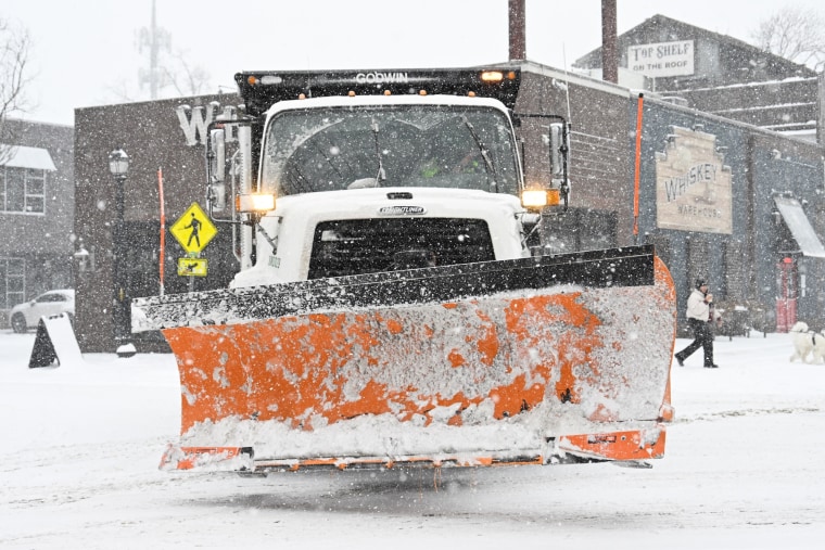 A snow plow on the road outside