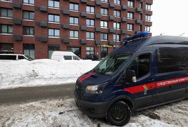 Pred stanovanjskim blokom v Moskvi, kjer je bil izveden poskus umora ruskega generala, je parkiran dostavni avto Ruske preiskovalne komisije. FOTO: Anastasia Barashkova/Reuters
