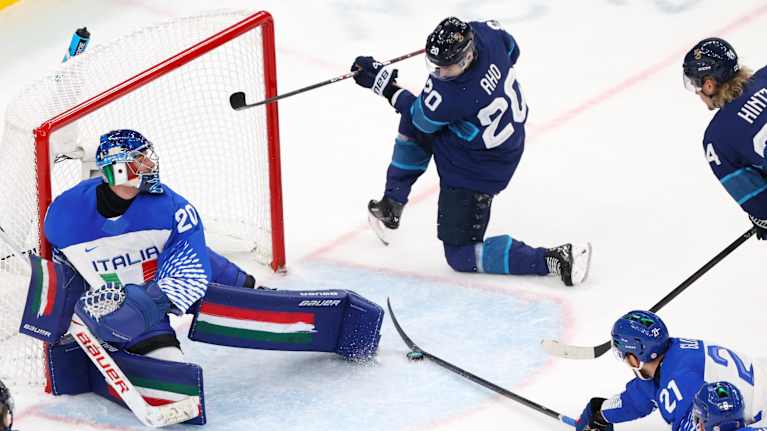 Italian pelaaja katkaisee syötön, jota Sebastian Aho odottaa maalin kulmalla jääkiekon olympiaturnauksessa.