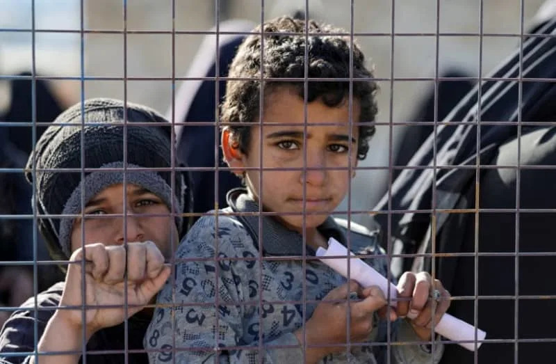 Children, part of a group of detainees, look through a fence at al-Hol camp after the Syrian government took control of it following the withdrawal of Syrian Democratic Forces (SDF), in Hasaka, Syria, January 21, 2026. (credit: REUTERS/KHALIL ASHAWI/FILE PHOTO)