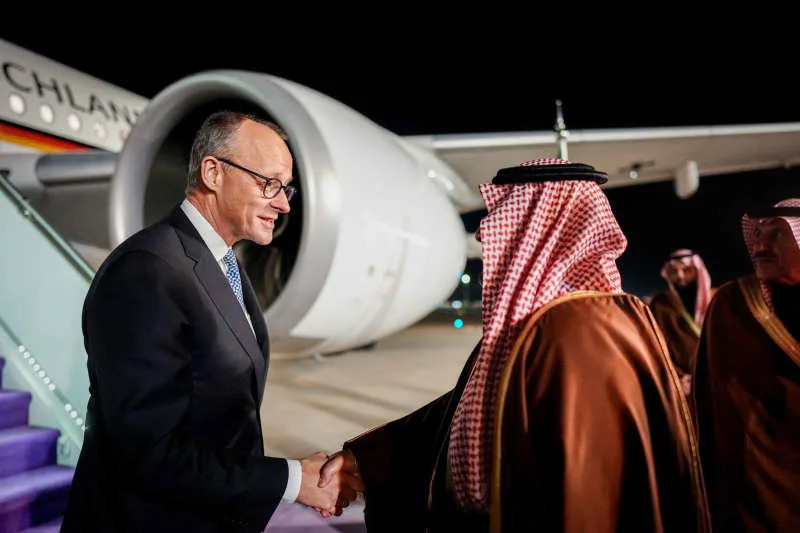 German Chancellor Friedrich Merz (C) welcomed by the Governor of Riyadh Prince Faisal bin Abdulaziz Al Saud upon his arrival at King Khalid International Airport's Royal Terminal. Kay Nietfeld/dpa