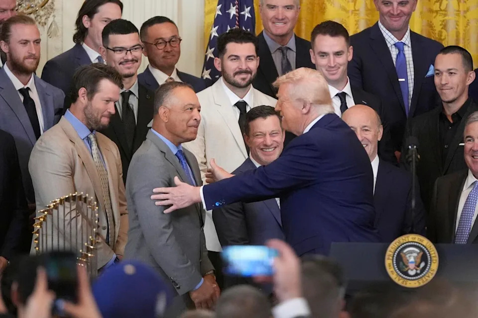 President Donald Trump greets manager Dave Roberts during a ceremony to honor.