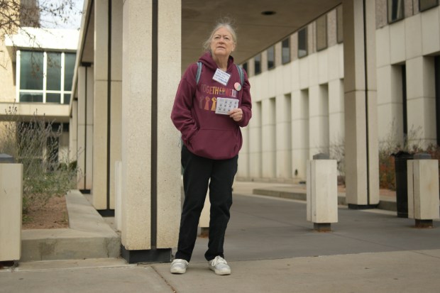 Joanne Belknap provides immigrants with information about their rights and bears witness to any potential ICE activity in front of the Byron Rogers Federal Building in Denver on Tuesday, Nov. 18, 2025. (Photo by Hyoung Chang/The Denver Post)