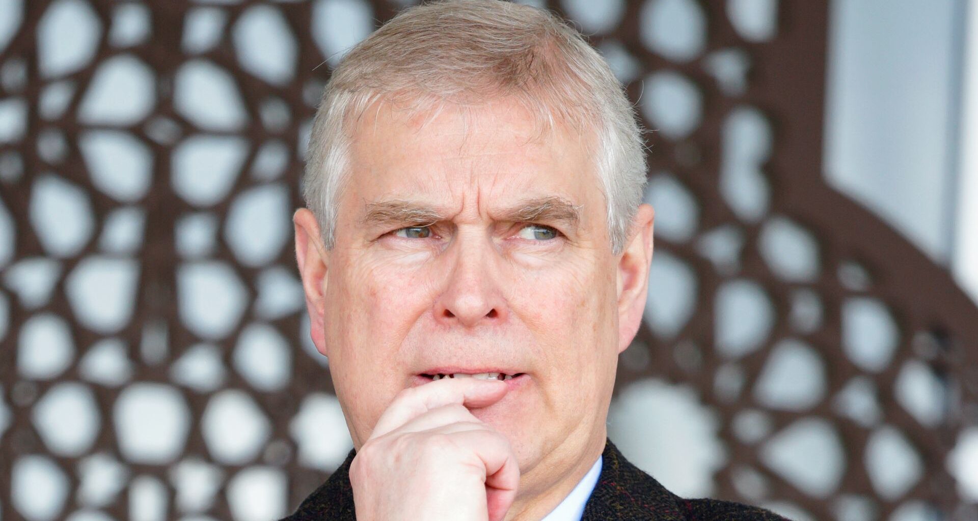 Prince Andrew wearing a black coat and looking anxious