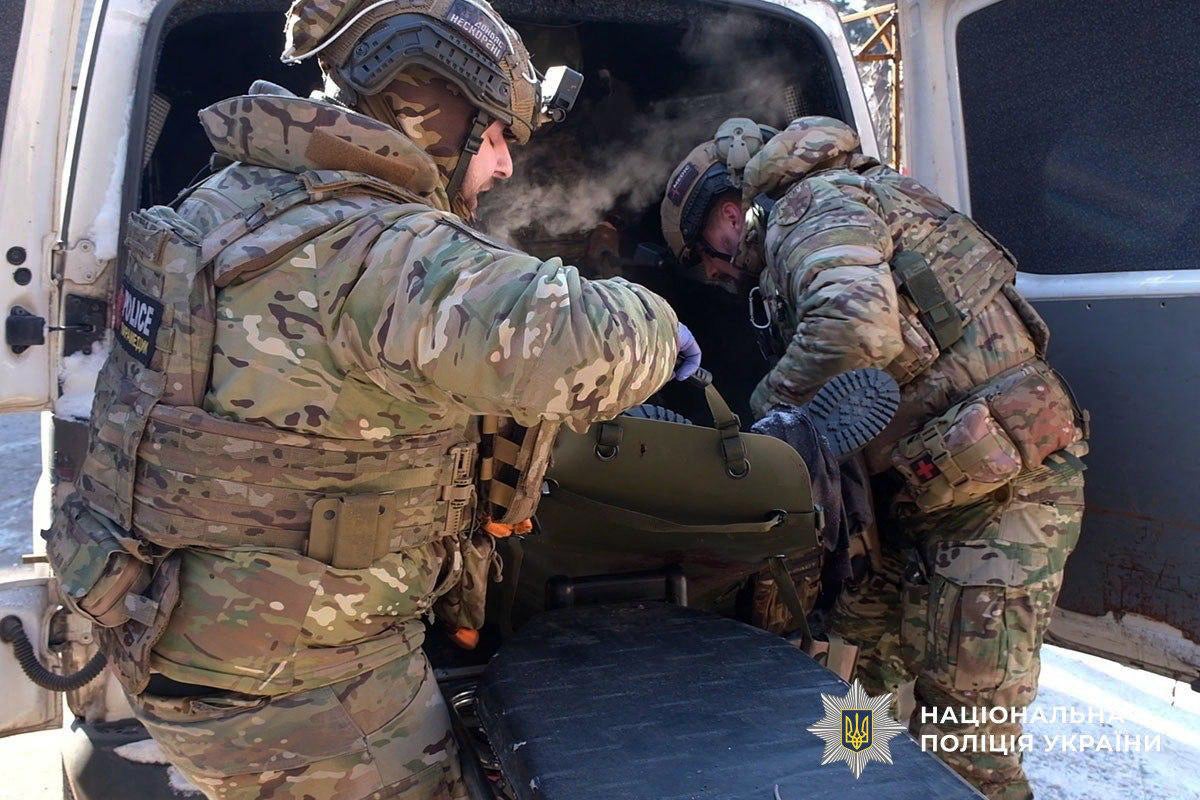 Ukrainian policemen carrying an injured civilian after a Russian strike in the town Druzhkivka in Donetsk region