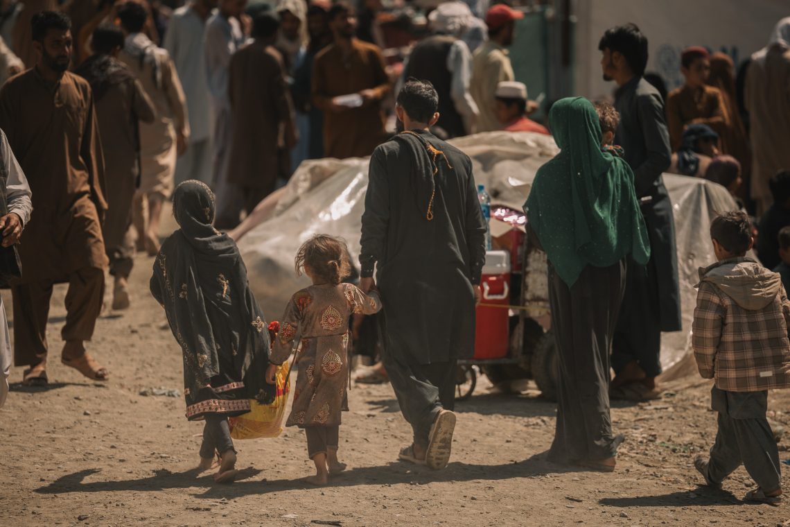 Returnees of Afghanistan walk through a crowded border crossing after being deported from neighboring countries, many seeking aid and shelter upon arrival.(Photo Credit: IOMAFGHANISTAN/X)