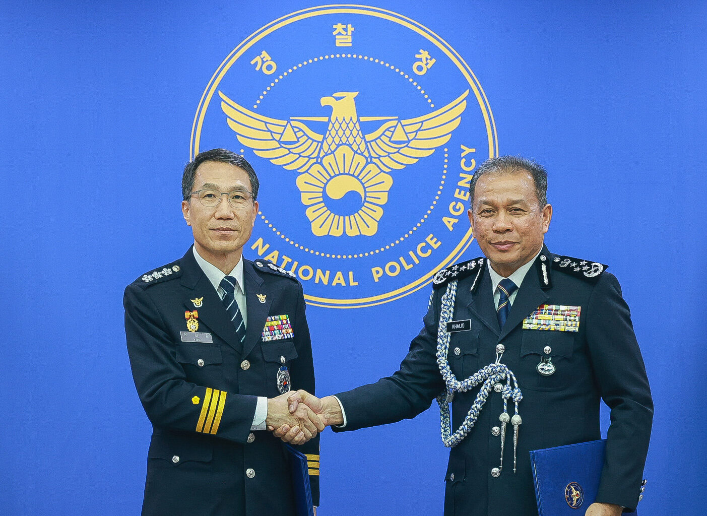 Acting National Police Agency chief Yoo Jae-seong, left, and his Malaysian counterpart, Mohd Khalid Ismail, shake hands as they meet for talks at Yoo's office in western Seoul on Feb. 4. [YONHAP]