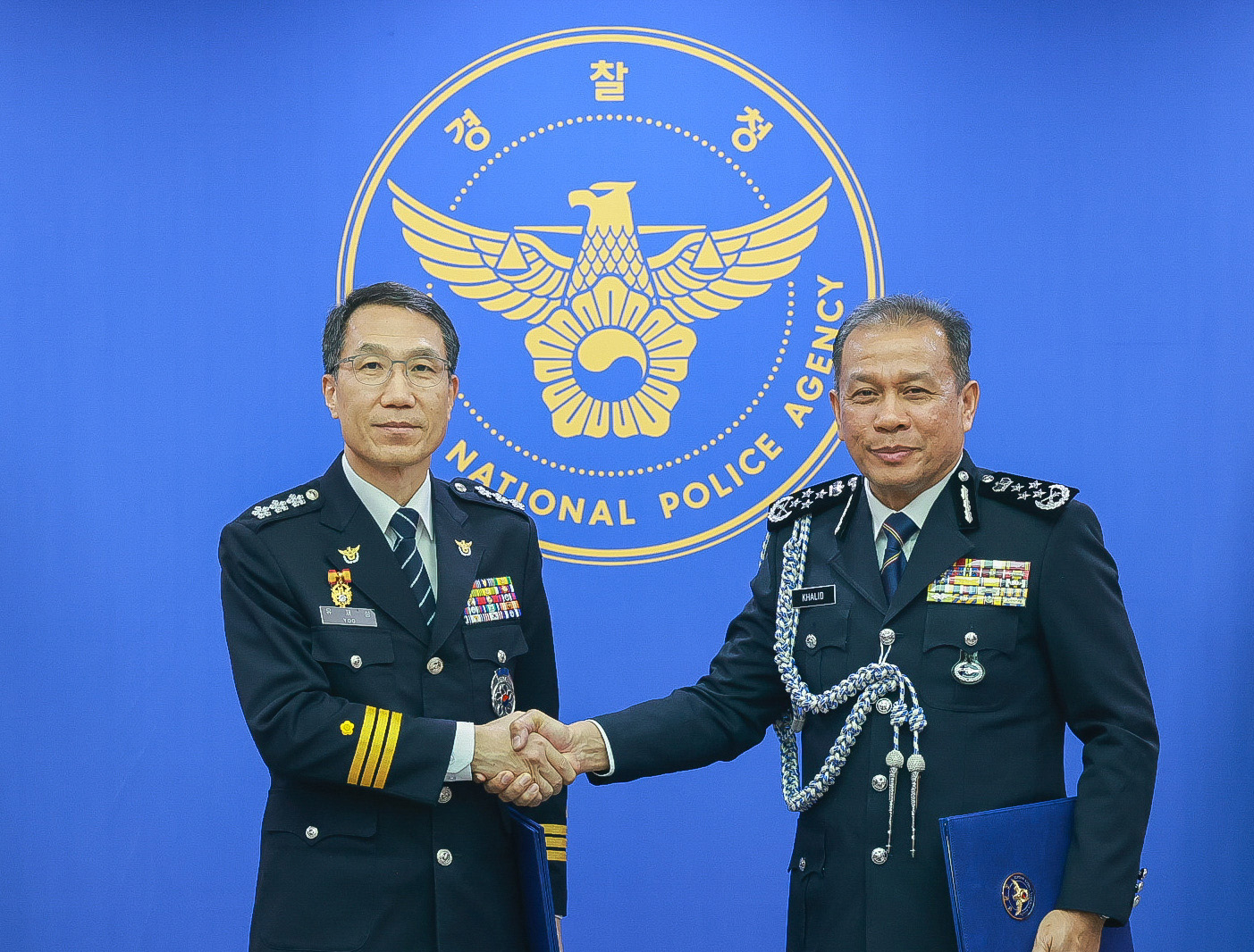 Acting National Police Agency chief Yoo Jae-seong, left, and his Malaysian counterpart, Mohd Khalid Ismail, shake hands as they meet for talks at Yoo's office in western Seoul on Feb. 4. [YONHAP]