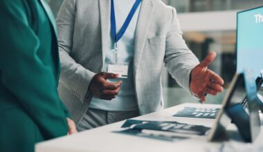 Welcome booth, conference and hands with business people at expo for summit, information or showcase