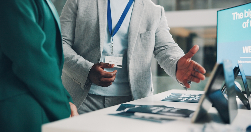 Welcome booth, conference and hands with business people at expo for summit, information or showcase