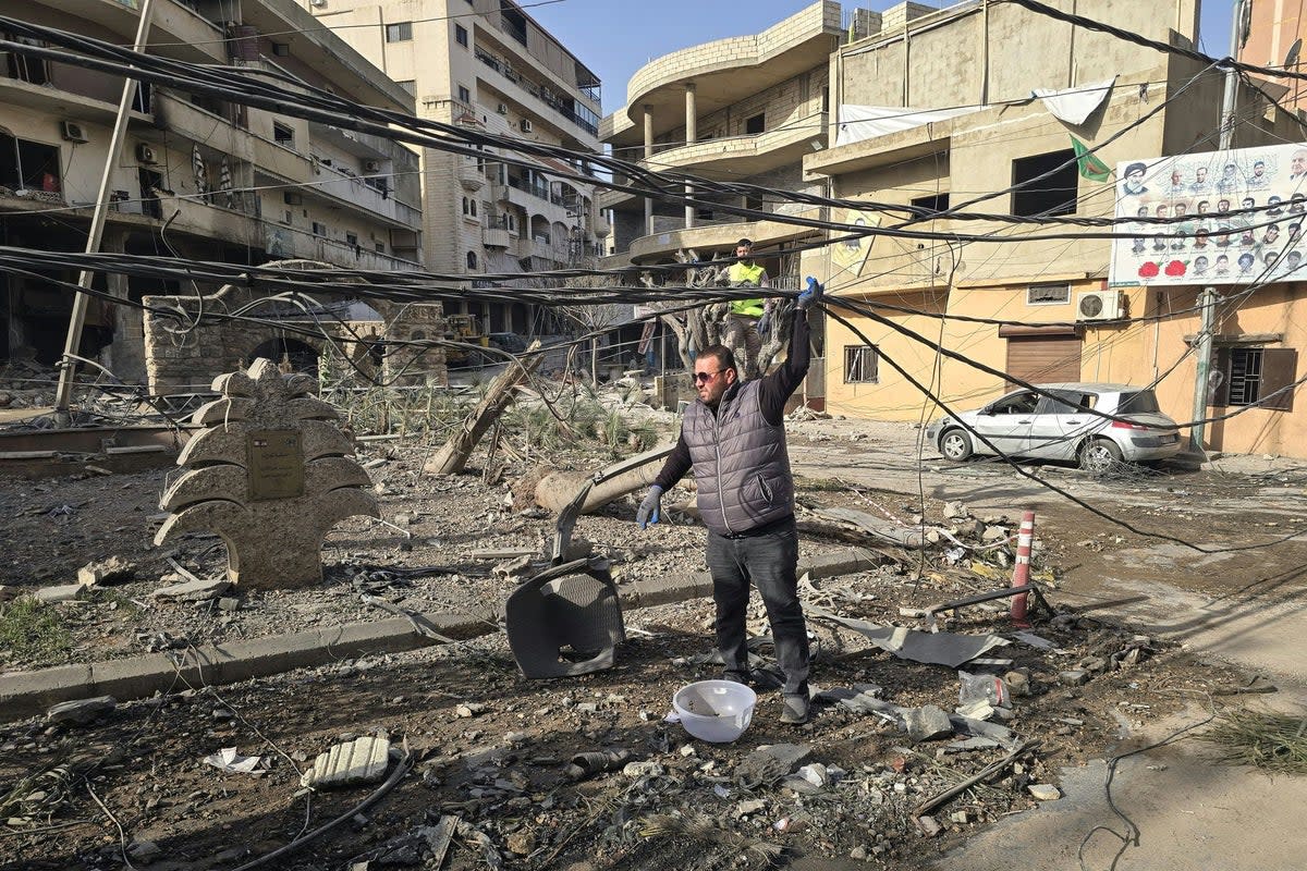 Municipality workers assess the damage from overnight Israeli airstrikes in the southern Lebanese coastal city of Tyre on 12 March 2026 (AFP via Getty)