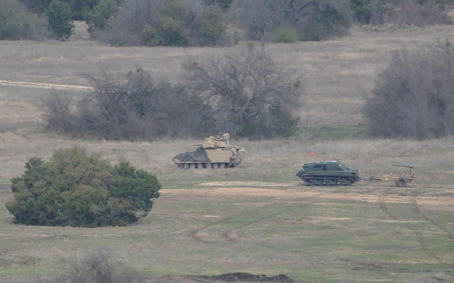 The tank rolls through path cleared by the unmanned vehicle.