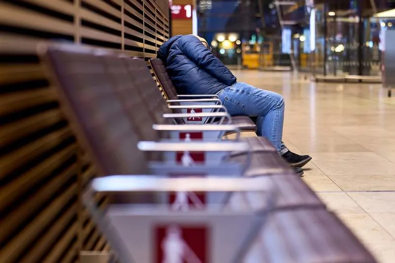 A lone traveler sits on a bench in Terminal 1 at Berlin Brandenburg Airport (BER), waiting. Due to a warning strike by the Verdi union, no passenger flights take off or land at BER, with all departures and arrivals canceled for the entire day, as previously announced by the airport operator. Michael Ukas/dpa