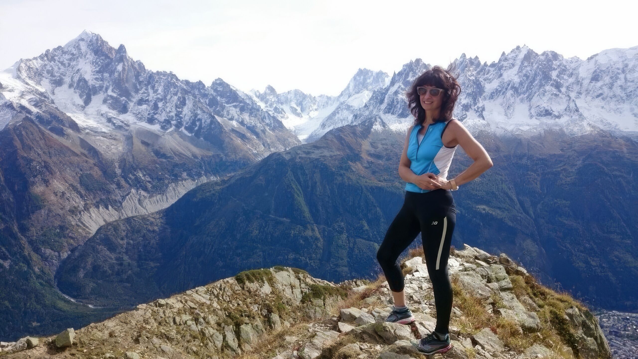 Rebecca standing on a mountain peak, symbolizing women’s resilience and an international journey across cultures.