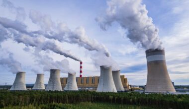 Image shows several cooling towers outside of a energy facility.