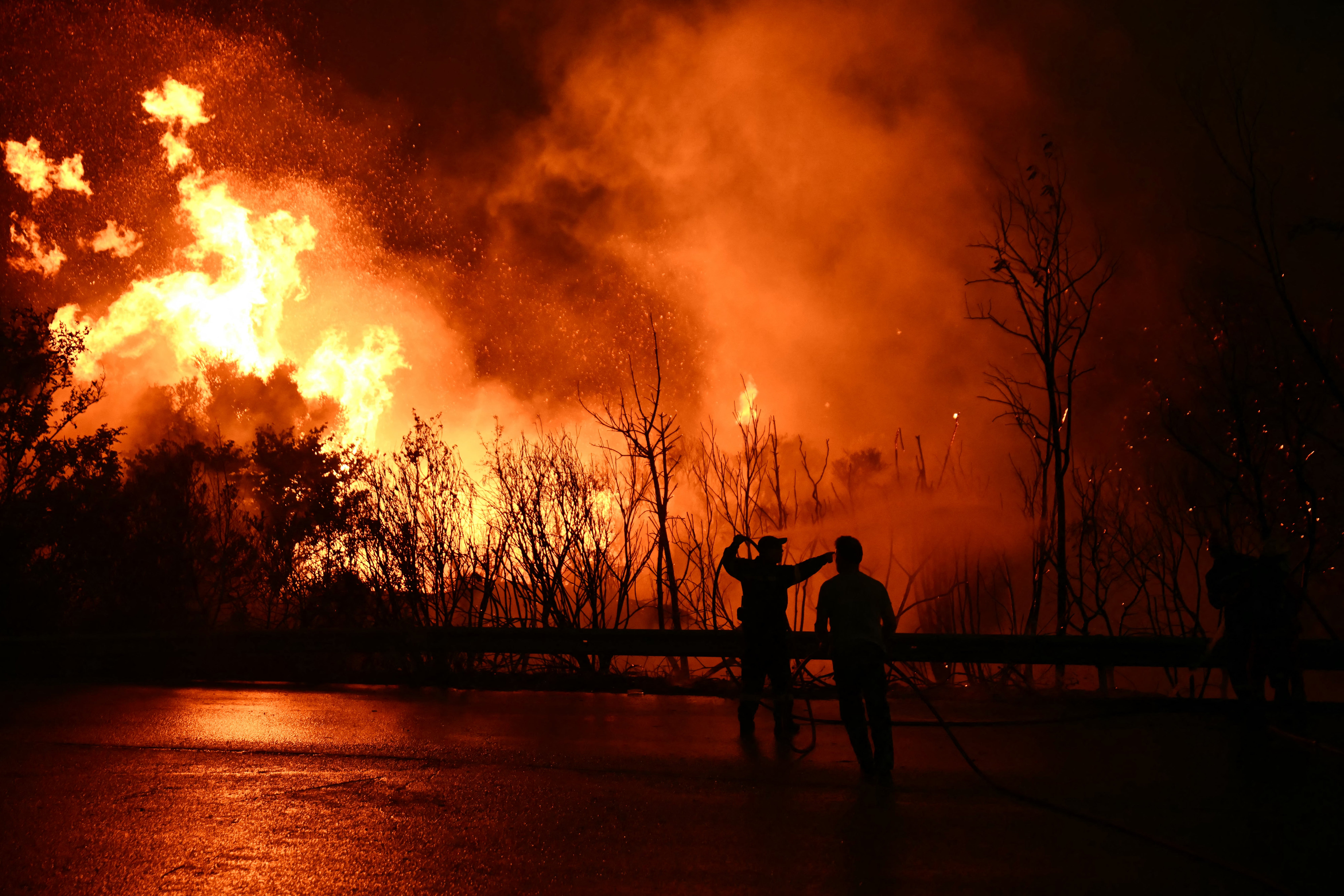 Firefighters work to extinguish a wildfire near the city of Patras in western Greece