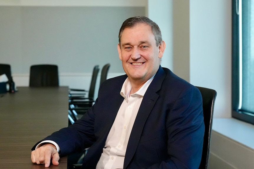 An executive in a suit jacket sitting at a table.