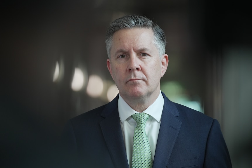 Mark Butler standing in a corridor in a suit