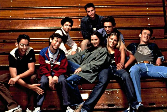 Group of young adults casually seated on bleachers, each displaying a distinct relaxed fashion style
