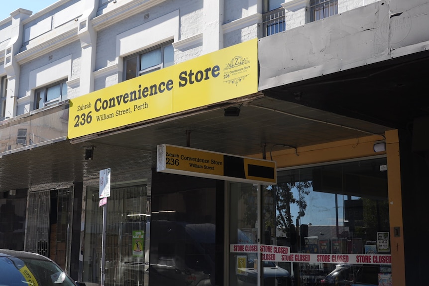 A shop front with 'store closed' banners stuck on the front windows