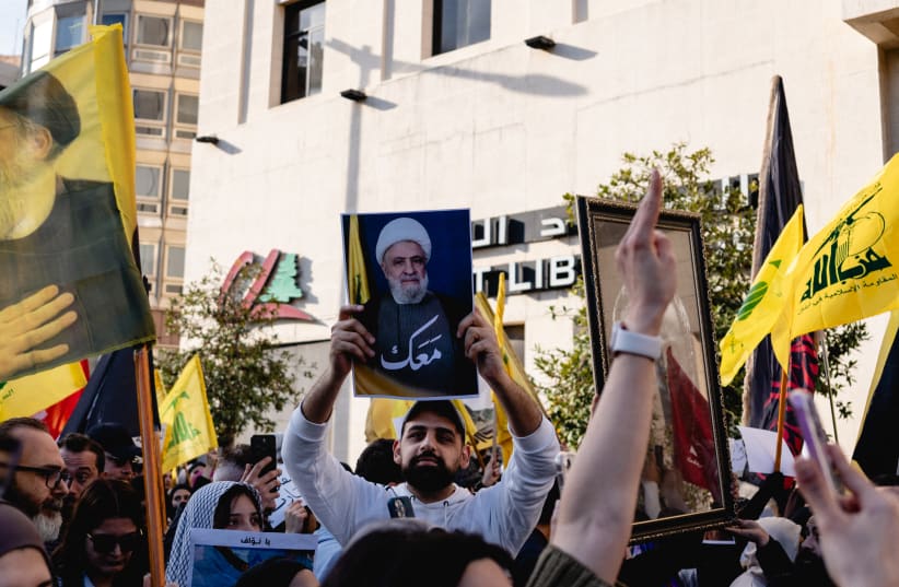 A protester holds a picture of Hezbollah leader Naim Qassem during a demonstration in Riad Al Solh Square in Beirut, Lebanon, on April 11, 2026.