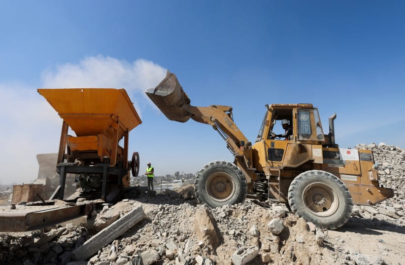 Heavy machinery crushes and moves rubble during sorting and recycling operations in Khan Younis, southern Gaza Strip, April 14, 2026.