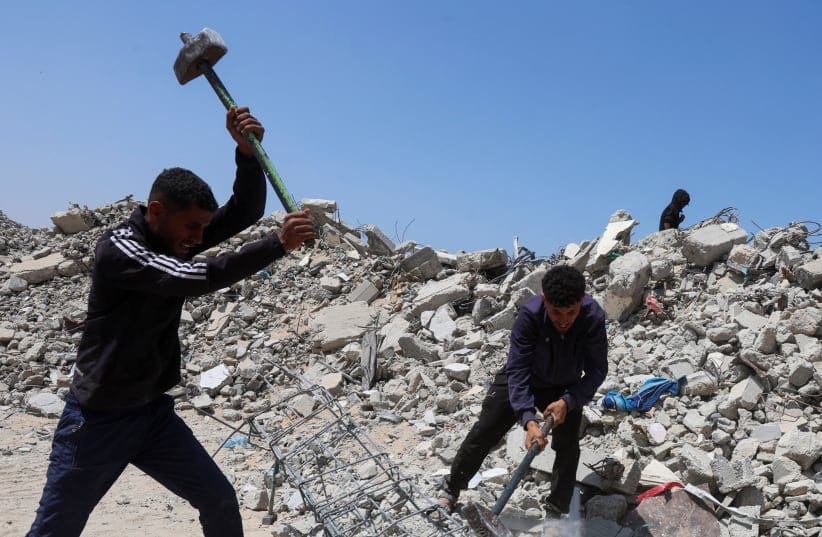 YOUNG PALESTINIAN workers break up concrete while working on rubble in Khan Yunis, in the southern Gaza Strip.