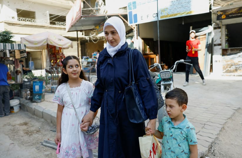 GHAZAL SANDID, a Palestinian refugee, walks with her children in the Yarmouk refugee camp in Damascus, Syria, September 22, 2025.