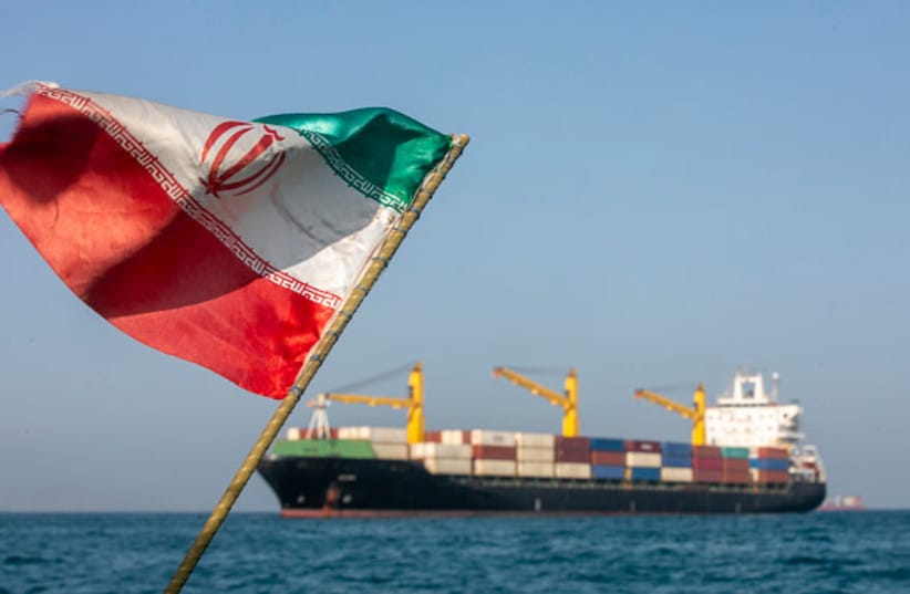 An Iranian flag flutters in the wind as ships remain anchored on May 16, 2026 in the Strait of Hormuz near Larak Island, Iran.