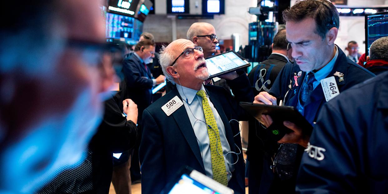 A trader at the NYSE looking up at a monitor amid a crowd of other traders