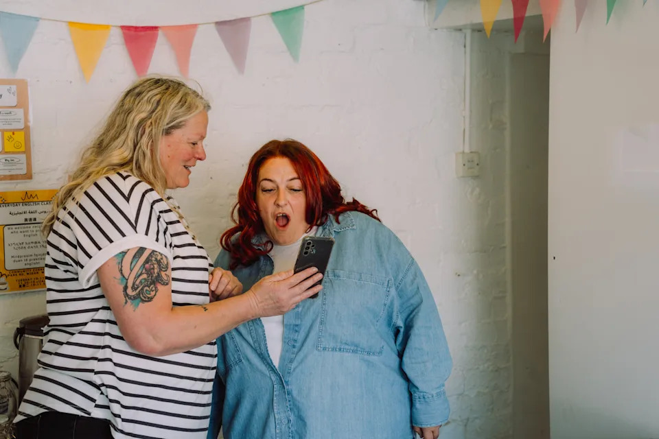 Two women look at a phone