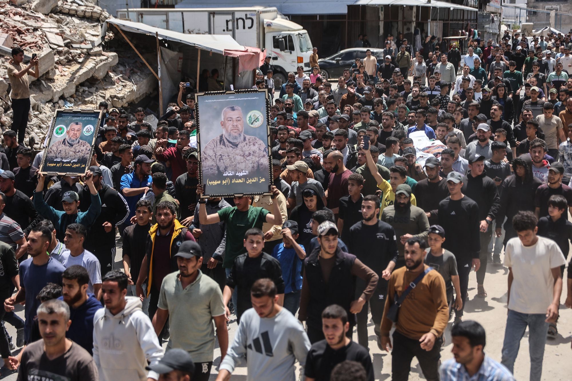 Mourners carry portraits of Ezzedine Al-Haddad, the slain chief of the Qassam Brigades -- the armed wing of Palestinian movement Hamas,