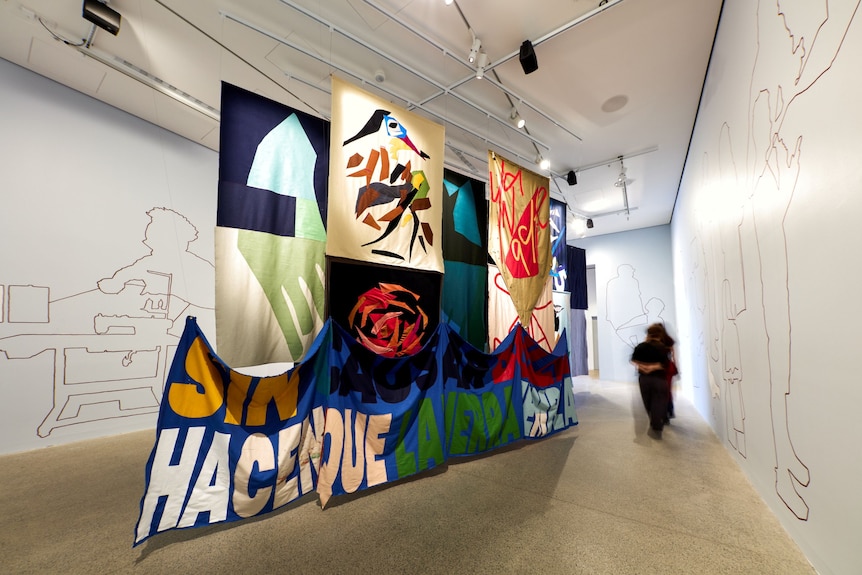 An art installation featuring textile banners hanging in a gallery space.