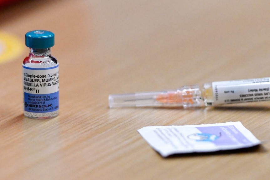 A vile of liquid and a syringe on a table